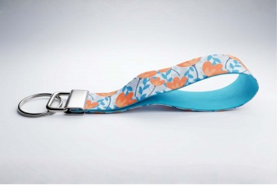 Modern kék-narancs virágmintás csuklópántos kulcstartó